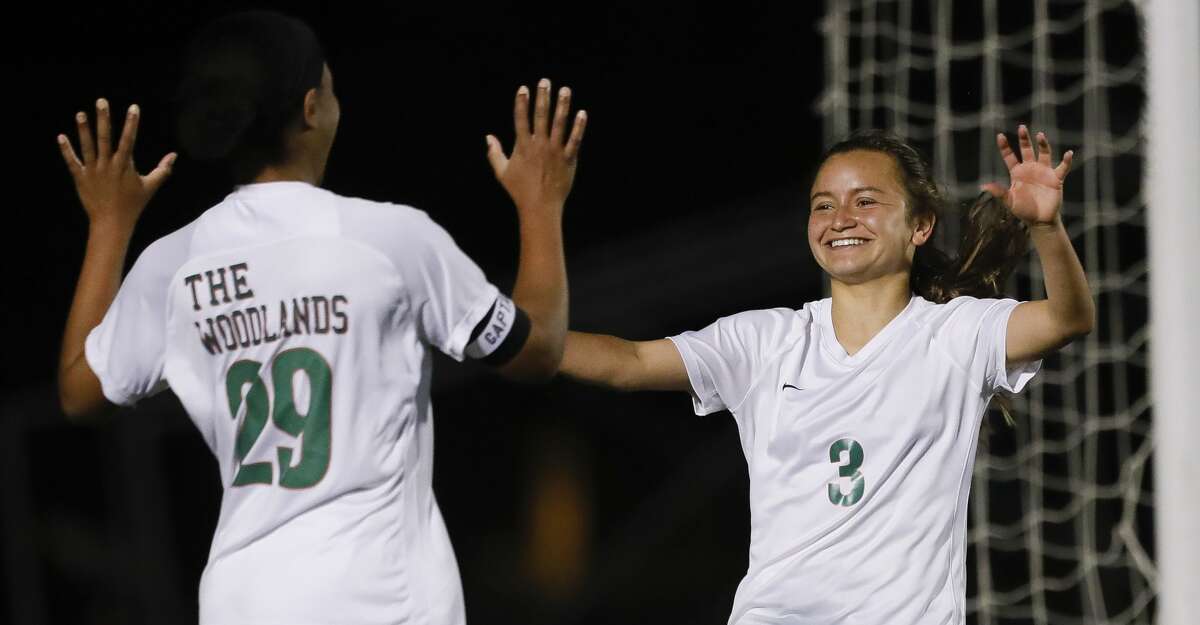 The Woodlands forward Katherine Williams (3) celebrates her third goal of the second period with forward Samone Knight (29) during a District 13-6A high school soccer match at College Park High School, Friday, March 19, 2021, in The Woodlands.