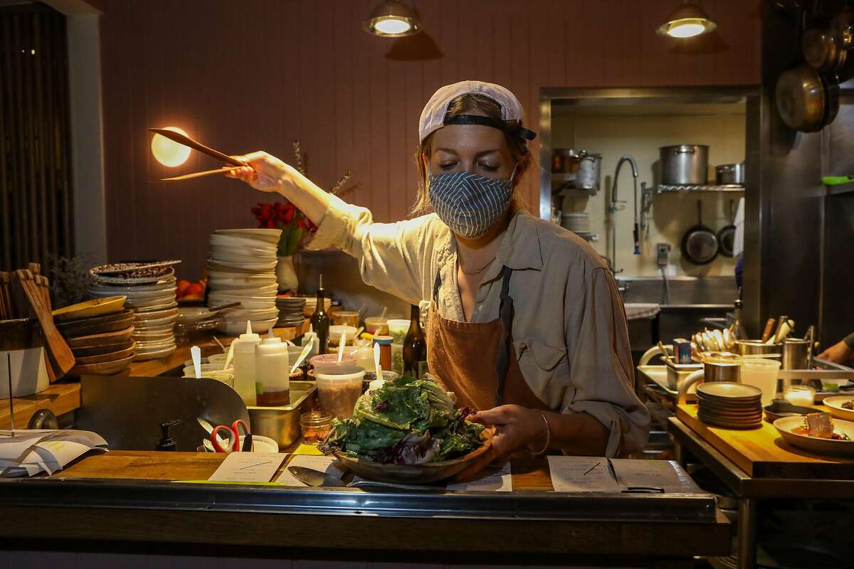 Emma Lipp, a co-partner, builds a salad in the kitchen during the dinner shift at Valley Bar & Bottle in Sonoma.