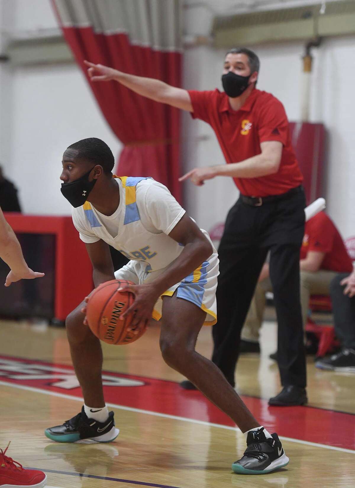 Kolbe Cathedral's Daniel Wellington handles the ball on the perimeter as Stratford Coach Tim Swaller directs his defense during the first half of the SWC tournament semifinals at the Cardinal Sheehan Center in Bridgeport, Conn. on Monday, March 22, 2021.