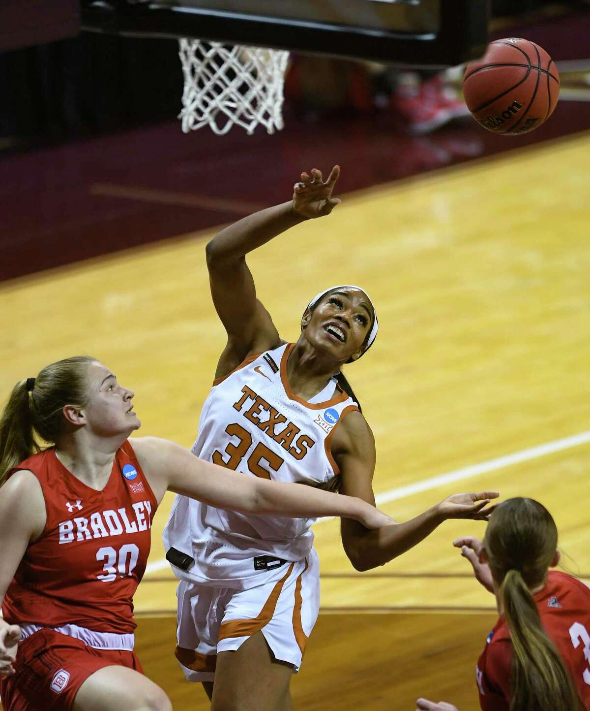Texas center Charli Collier (35) battles Emily March (30) and Gabi Haack (3) of Bradley for a rebound during the first round of the NCAA Division I Women's Basketball Tournament in San Marcos on Monday, March 22, 2021.