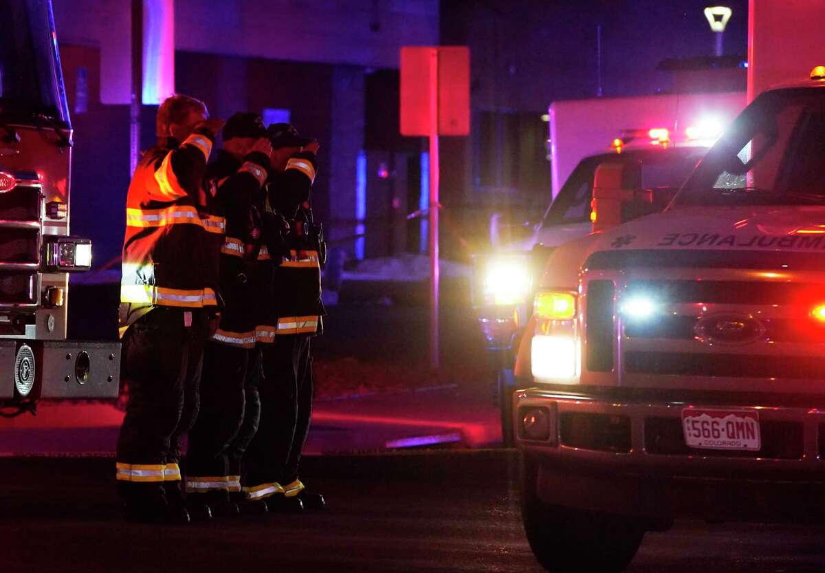 Firefighters salute an ambulance as it leaves a King Soopers grocery store where authorities say multiple people have been killed in a shooting, Monday, March 22, 2021, in Boulder, Colo.