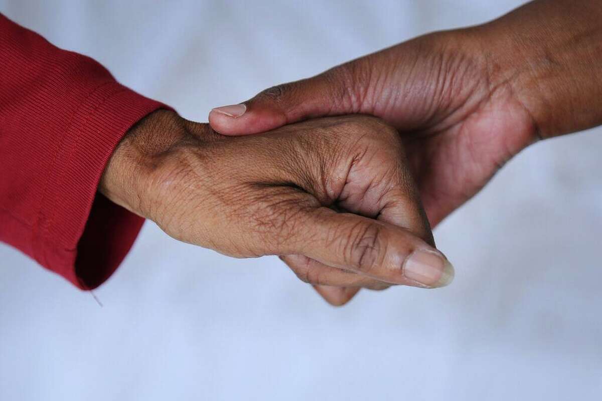 From left: Hulda Brown and nurse care coordinator Eva Mureithi hold hands at San Francisco General Hospital's Ward 86 on Friday, Sept. 15, 2017, in San Francisco, Calif. Brown, age 73, was diagnosed HIV positive in 1991. She's been getting treatment at the hospital for more than two decades.