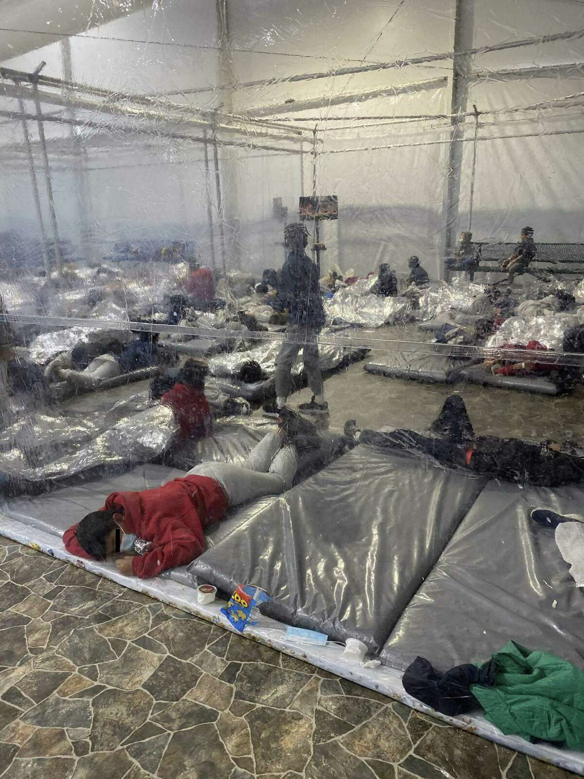 Migrants are seen inside of a US Customs and Border Protection temporary overflow facility in Donna, Texas