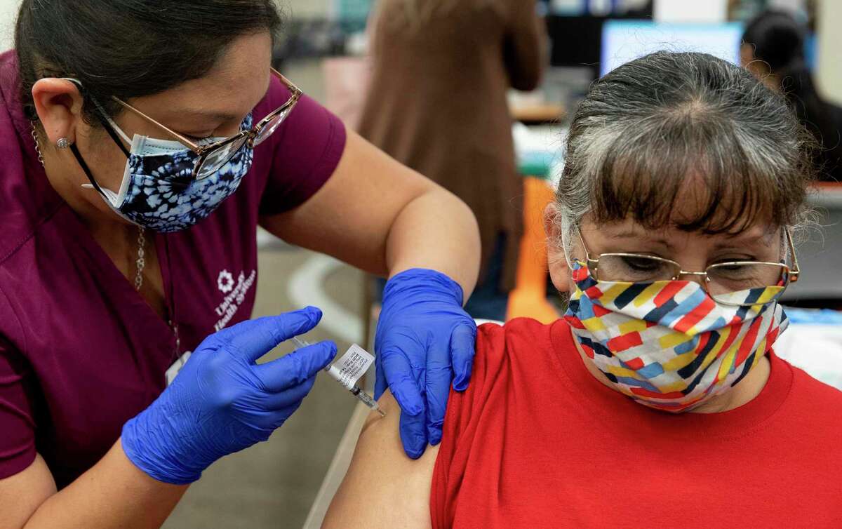 Janie Castillo, a cook for San Antonio ISD, receives her vaccine from Crystal Julian, a medical assistant at University Health, during a two-day effort last month to vaccinate 5,000 employees of the school district.
