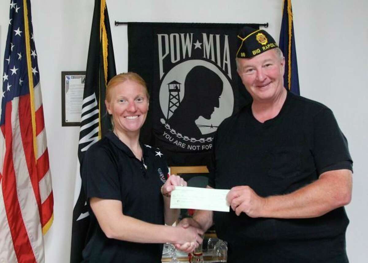 In this Pioneer file photo, Bill Yontz (right), commander of the American Legion Post No. 98, presented Kelli Johansen, with Mid-Michigan Honor Flight, with a $500 donation. (Pioneer file photo)