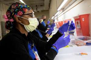 Cynthia Harris, a pharmacy tech from University Health, prepares a vaccine that will go to 1 of 5,000 SAISD employees at Wonderland of the Americas Mall over the next 2 days.