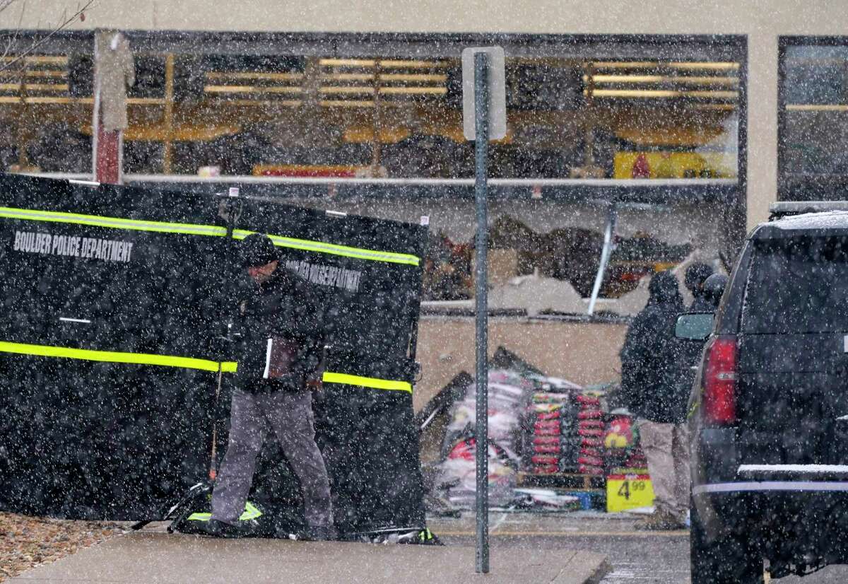 A snow squall envelops investigators as they collect evidence around the parking lot where a mass shooting took place in a King Soopers grocery store Tuesday, March 23, 2021, in Boulder, Colo.