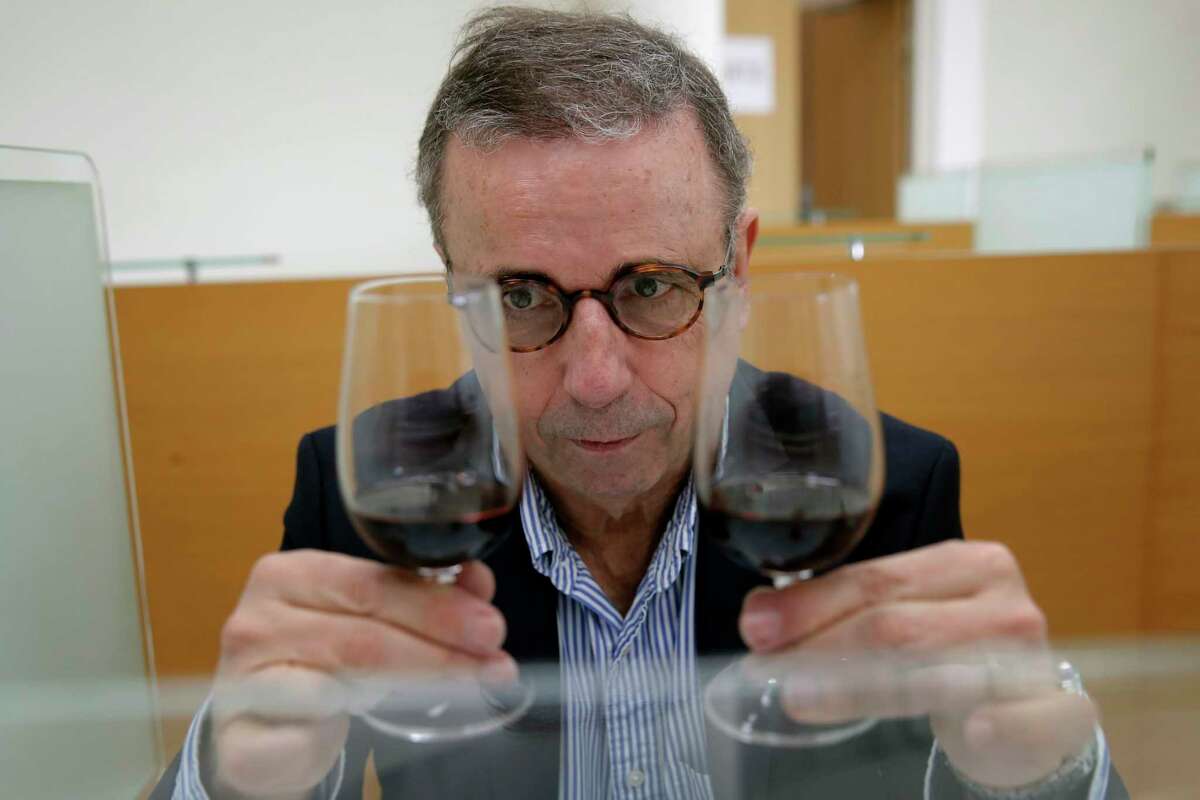 Bordeaux Mayor Pierre Hurmic checks glasses of wine, during a tasting session, with one glass containing wine that spent a year orbiting the world in the International Space Station, at the Institute for Wine and Vine Research in Villenave-d'Ornon, southwestern France, Monday, March 1, 2021.