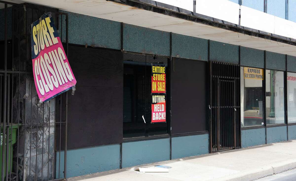 A store closing sign hangs off  the gate of a closed down business, Tuesday, March 23, 2021, in downtown Laredo.