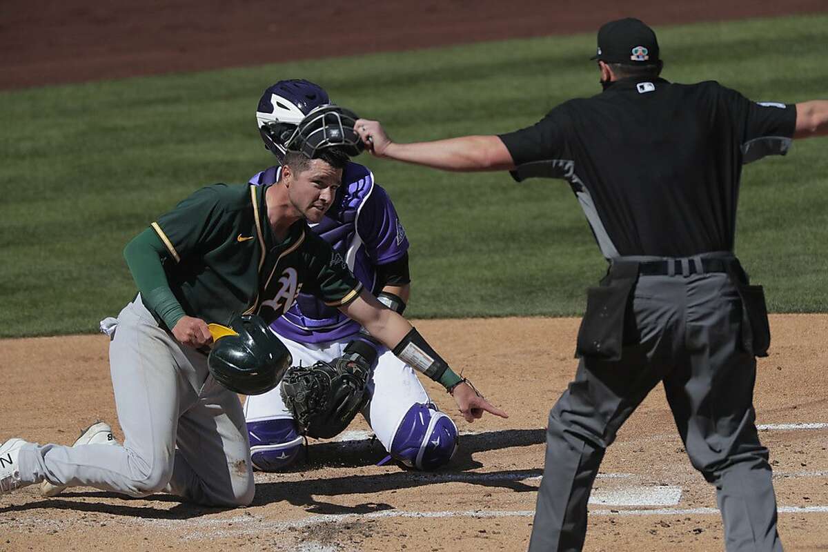 Austin Allen (30) safe at home on a hit by Pete Kozma (38) in the second inning as the Oakland Athletics played the Colorado Rockies in a spring training game at Salt River Fields at Talking Stick Park in Scottsdale, Ariz., on Wednesday, March 3, 2021
