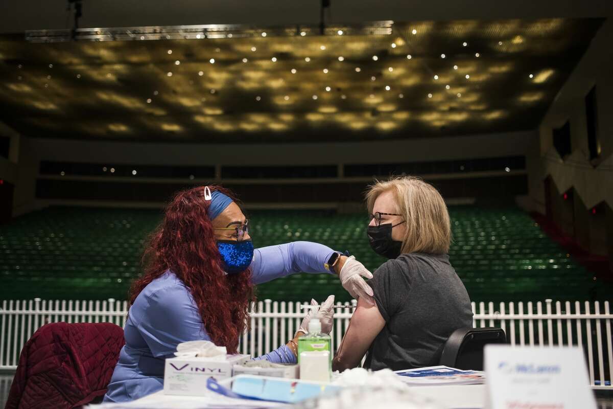 Sherry Stewart, an RN with Walgreens, left, administers the Pfizer COVID-19 vaccine to Erin Aspiranti of Midland, right, during a clinic held in partnership with Walgreens Wednesday, March 24, 2021 at the Midland Center for the Arts. (Katy Kildee/kkildee@mdn.net)
