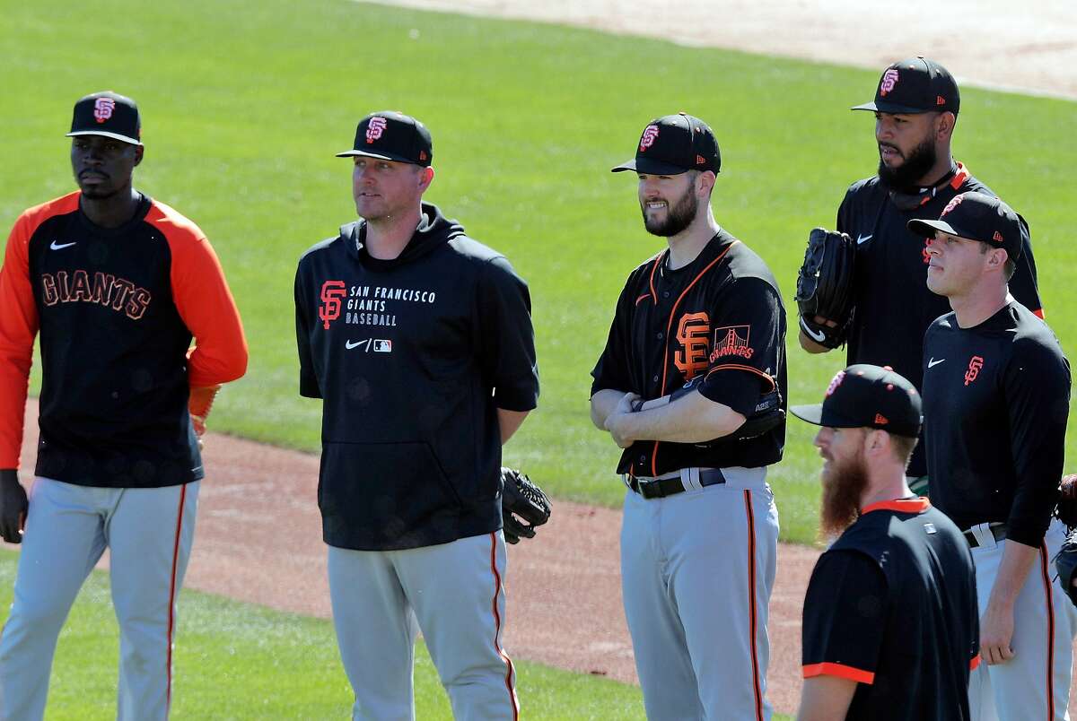 Pitchers, Alex Wood (57), and Jake McGee (17), center, were former Dodgers teammates and now on the practice field as the San Francisco Giants worked out at Scottsdale Stadium in Scottsdale, Ariz., on Monday, March 1, 2021.