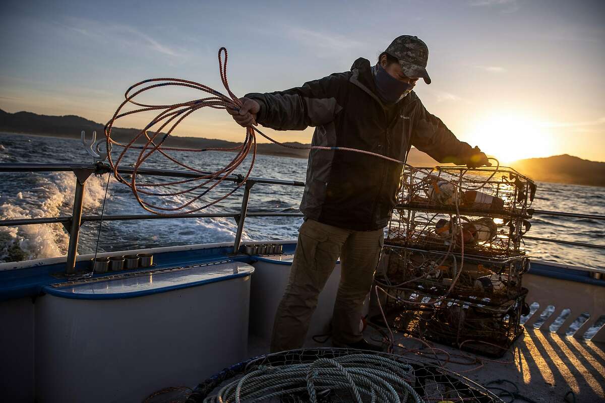 Michael Cabanas coils a rope as he prepares crab pots aboard the Huli Cat in Half Moon Bay.