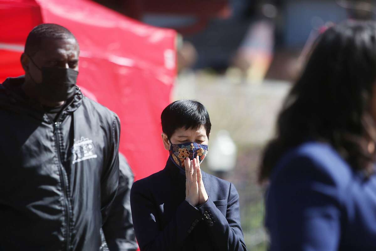 Anni Chung (center). president and CEO Self Help for the Elderly, holds her hands together as she listens to Mayor London Breed speak at a press conference at Portsmouth Square announcing the coalition of the Street Violence Intervention Program and Chinatown Community Youth Center to form the Coalition for Community, Safety and Justice on Wednesday, March 24, in San Francisco, Calif.