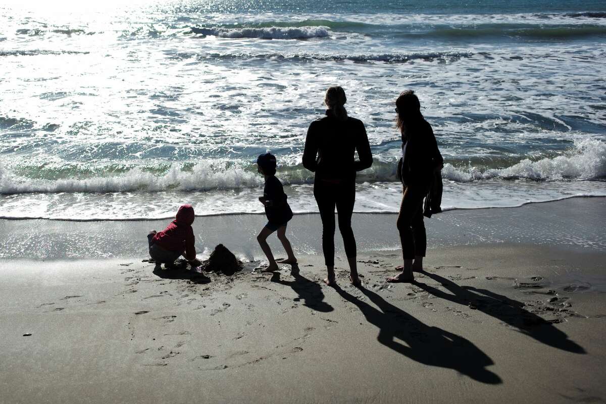 People enjoy their leisure time on a beach in Half Moon Bay in California, the United States, Feb. 28, 2021. 