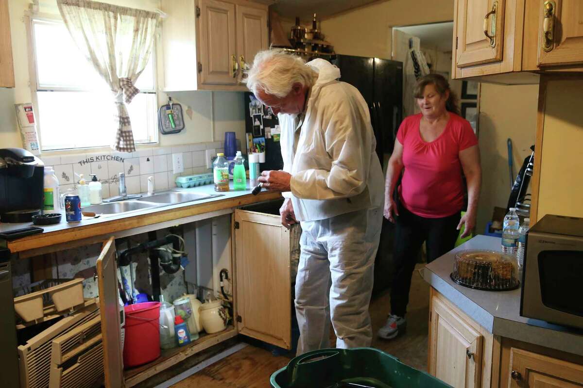 George Plumbing Company Master Plumber Dan Foster assesses work needed on the kitchen sink of Brenda Love's trailer home in Cibolo, Texas, Friday, March 12, 2021.