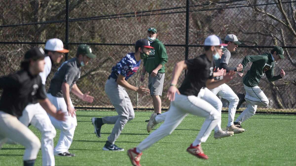 Norwalk baseball coach Ryan Mitchell watches from a distance as the Bears run sprints during the first week of pitchers and catchers for the baseball preseason at the Nathan Hale Middle School field on Tuesday, March 23, 2021.