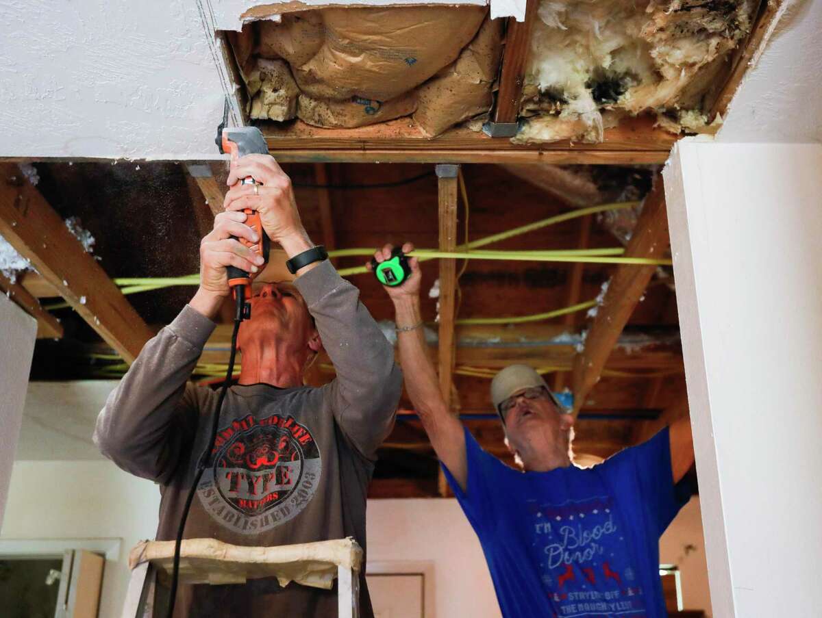 Allan Schneider, left, cuts drywall as Jerry Neuberger measures a wall while helping repair Delia Brown’s water-damaged home from February’s arctic blast, Tuesday, March 23, 2021, in Conroe. ‘They’ve been such a blessing to me,” Brown said. “I don’t know what I would have done without them.” Schneider and Neuberger are part of The Woodlands Methodist Church’s 60-member ‘Geezer Group,’ a group of volunteers help those in need with small construction projects usually after natural disasters.