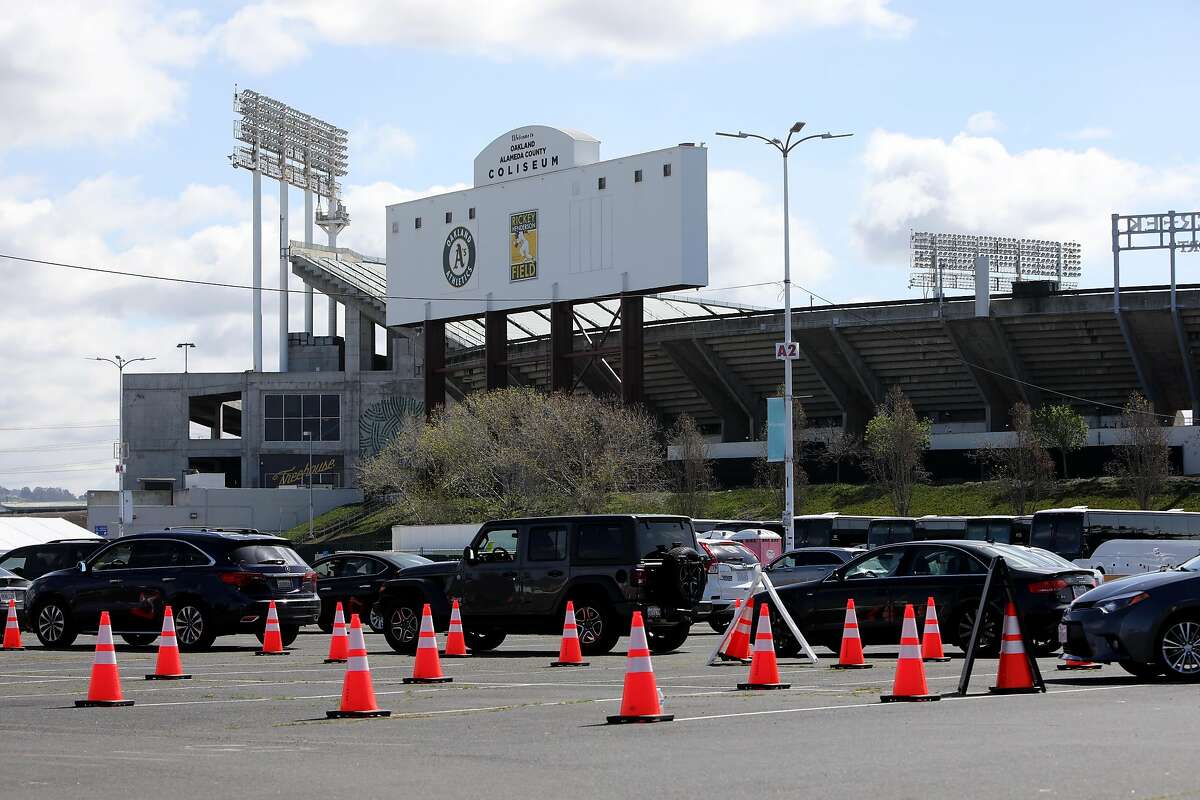 Vehicles wait at the Oakland Coliseum vaccination site on Thursday. Alameda County is in talks to take over operation of site from the state and federal government.