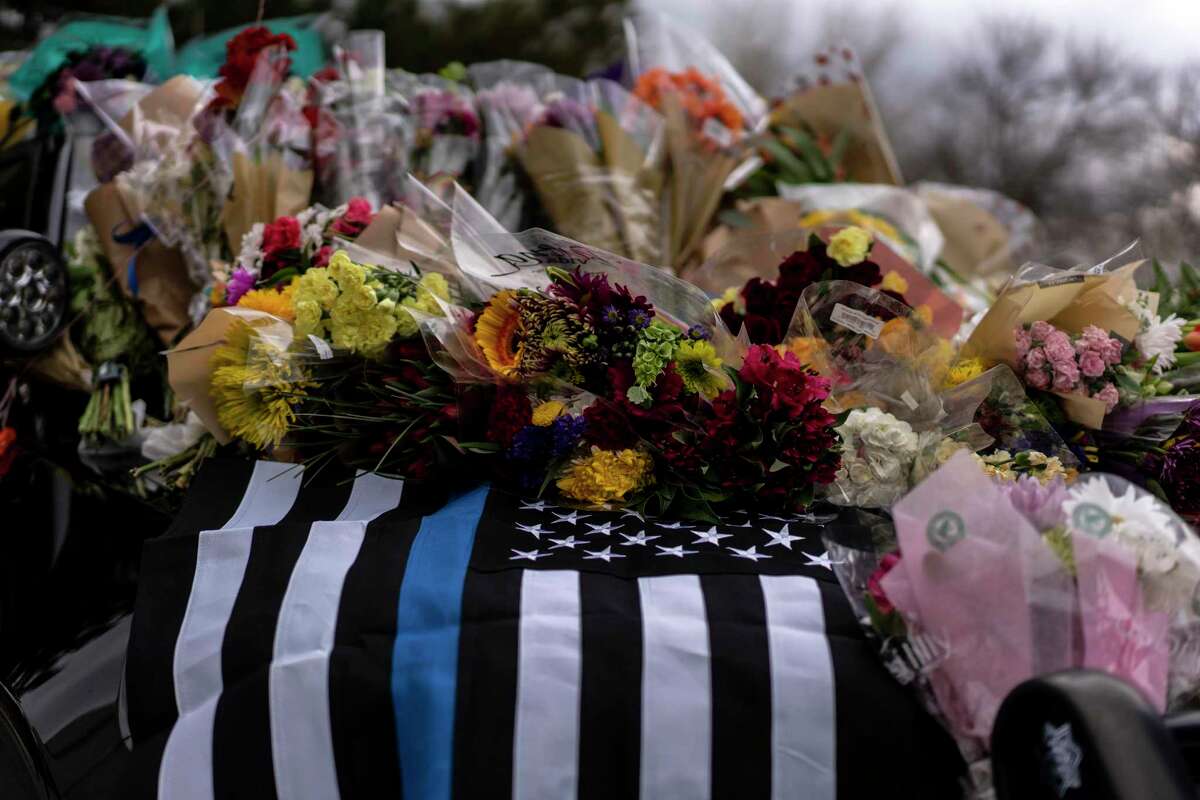 BOULDER, CO - MARCH 23: An American flag is draped over a patrol car outside of the Boulder Police Department adorned with flowers in honor of Officer Eric Talley, the day after a gunman opened fired at a King Sooper's grocery store on March 22, 2021 in Boulder, Colorado. The suspect, Ahmad Al Aliwi Alissa, 21, was reportedly charged in the shooting at a grocery store where ten people were killed, including police Officer Talley. (Photo by Chet Strange/Getty Images)