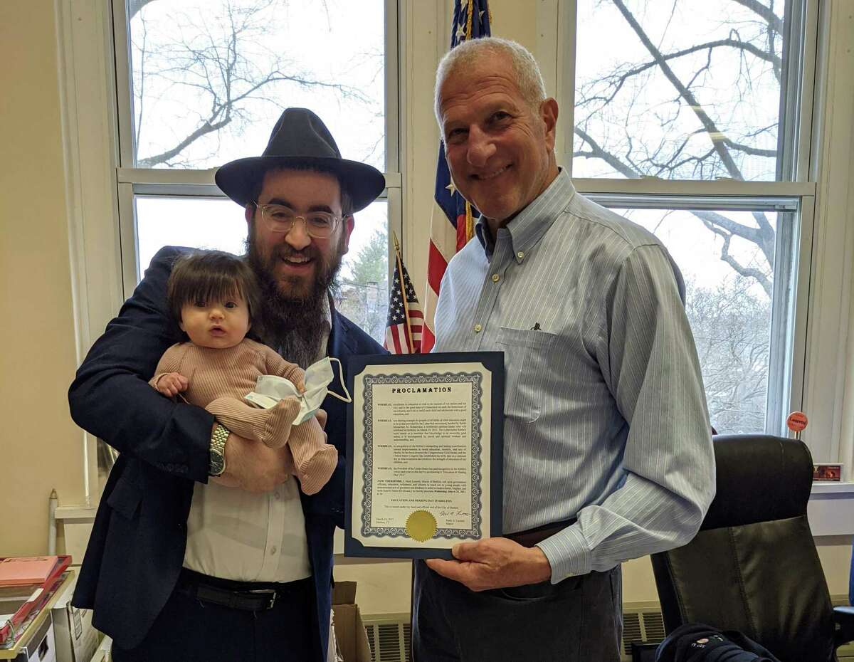 Mayor Mark Lauretti proclaimed March 24 Education and Sharing Day in Shelton. Lauretti celebrates the proclamation in his office with Rabbi Shneur Brook and his daughter, Dusya.