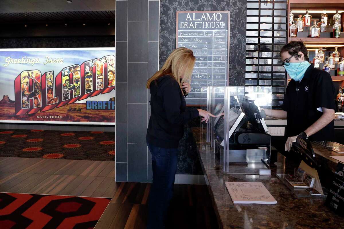 Tammy McCool buys movie tickets to celebrate her 28th wedding anniversary as she waits for her husband at the Alamo Draft House Cinema Thursday, Mar. 18, 2021 in Katy, TX.