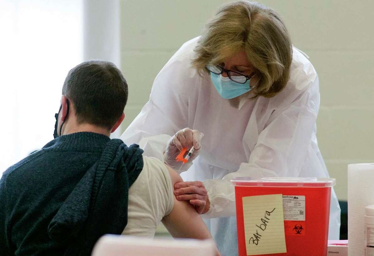 Karen Lynch, a nurse at Danbury Hospital, administers the Moderna COVID-19 vaccination to Danbury teachers and school district staff at a vaccine clinic at Rogers Park Middle School in Danbury, Conn., on Saturday Mar. 6, 2021.