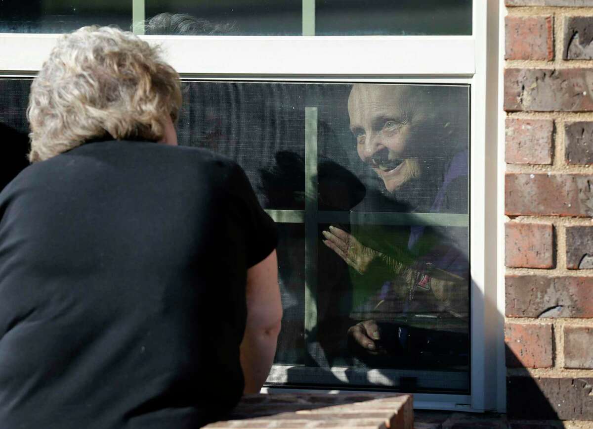 A woman visits her mother at a nursing home in Mansfield, Texas, in March 2020. The Texas Senate on Wednesday approved a bill that would guarantee that people in nursing homes and long-term care facilities could still receive visits from loved ones even in a pandemic. (Vernon Bryant/The Dallas Morning News/TNS)