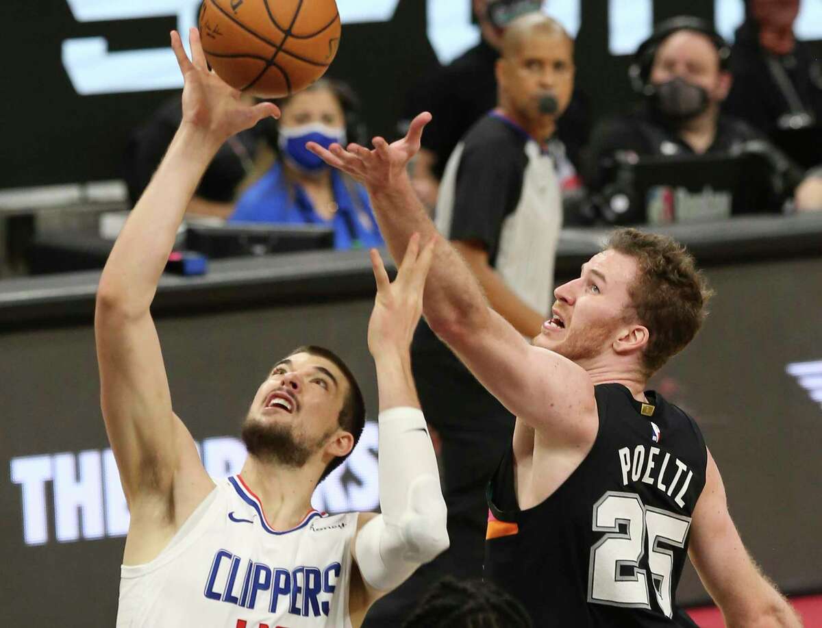 Spurs' Jakob Poeltl (25) battles for a rebound against the Los Angeles Clippers' Ivica Zubac (40) at the AT&T Center on Thursday, Mar. 25, 2021.
