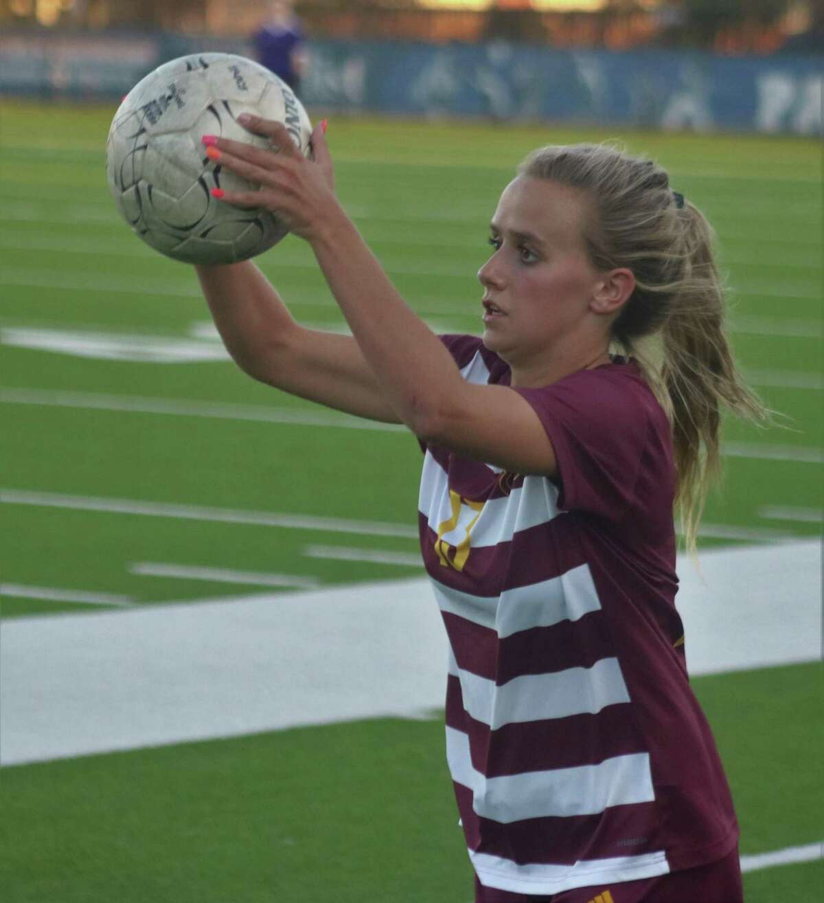 Audrey Addison eyes a teammate for the throw-in during second-half action in their state playoff match Thursday night.