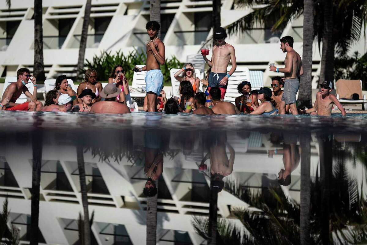 Visitors sit poolside March 18 at the Grand Oasis Cancún resort in Cancún, Mexico.