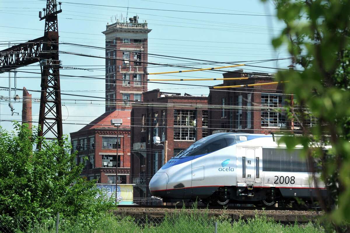 An Amtrak Acela train passes near Crescent Crossing, a new affordable housing development in Bridgeport.