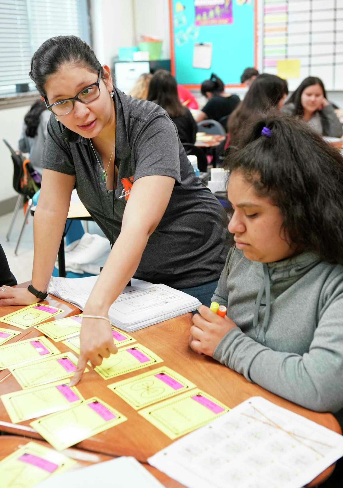 Navarro Middle School teacher Ana Steen, pictured in 2019, works with eighth-grader Jazzmin Gutierrez and others at her table during an algebra class at the Houston ISD campus. Navarro is one of 13 neighborhood middle schools that does not have a magnet program, making it harder to attract students who would bring more money to the east side campus.