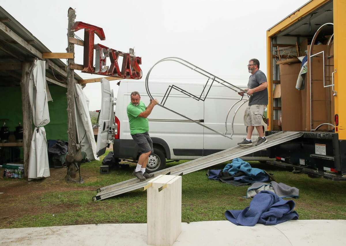 Tim Mashburn, left, and his husband Chris Gibbie, right, unload furniture items from a moving truck as they work to get their booth ready at Marburger Farm Antique Show, on Wednesday, March 24, 2021, in Round Top, Texas. Gibbie and Mashburn are co-owners of Halsey Dean Gallery and have been part of the show 17 times over the last 9 years.