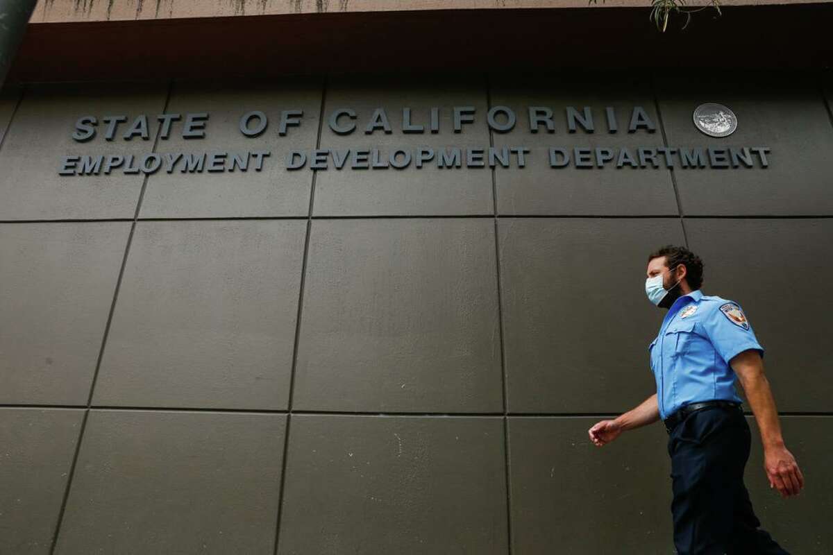 A man walks by the Employment Development Department' San Francisco office in 2020. A prison inmate, a nurse and a car dealer employee used the dark web to bilk California's troubled unemployment system of almost $2 million.