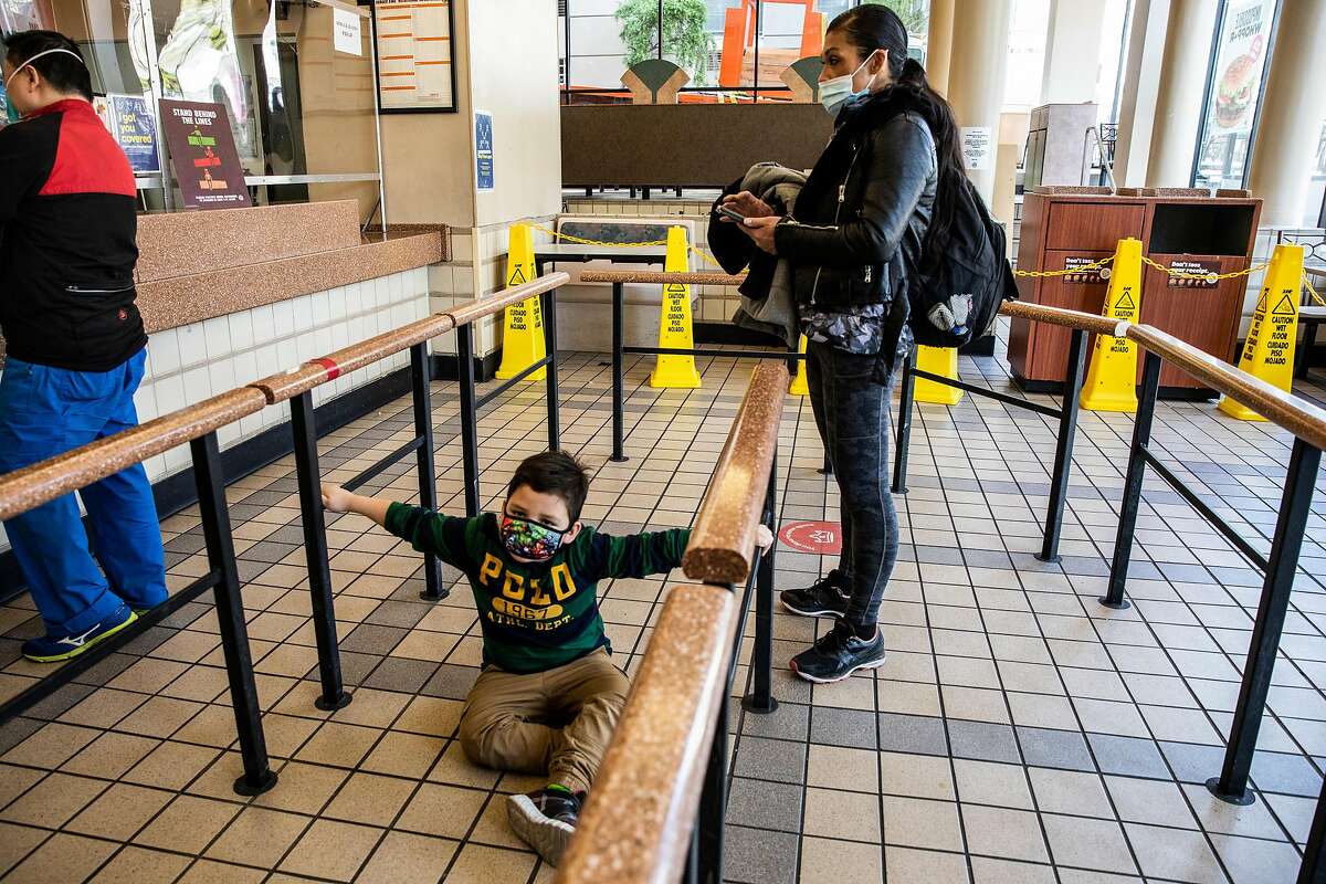 Douglas Jones, 5, briefly sits on the floor inside Burger King as mother Juthaporn Chaloeicheep gets ready to order. Chaloiecheep, a mother of five, was homeless for 20 years.