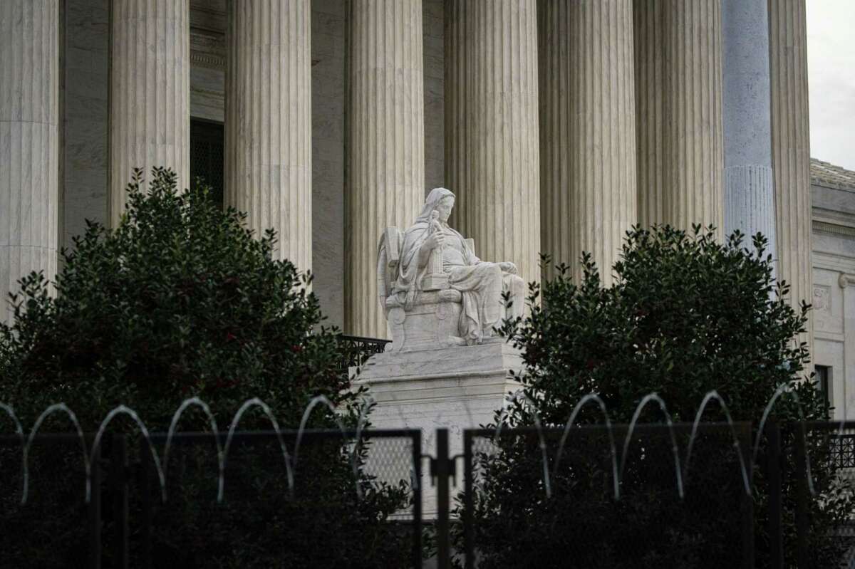 The statue "Contemplation of Justice" by sculptor James Earle Fraser behind temporary security fencing outside the U.S. Supreme Court in Washington, D.C., on March 12, 2021.