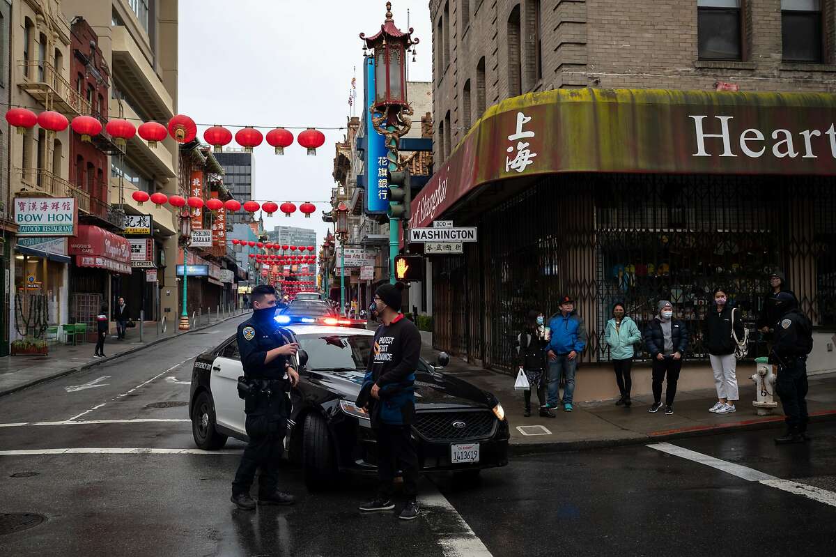 San Francisco police Officer William Ma chats with and Chinatown Safety Patrol co-founder Forrest Liu on March 18, 2021. Ma’s partner said they volunteered for the Chinatown beat because of the familial ties to the district.