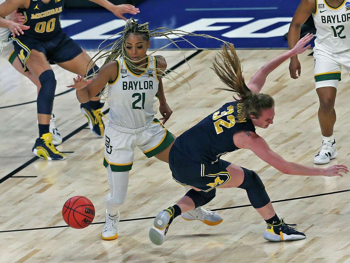 Baylor guard Dijonai Carrington (21) steals the ball from Michigan guard Leigha Brown (32) in the first half on Saturday, March 27, 2021 at the Alamodome.