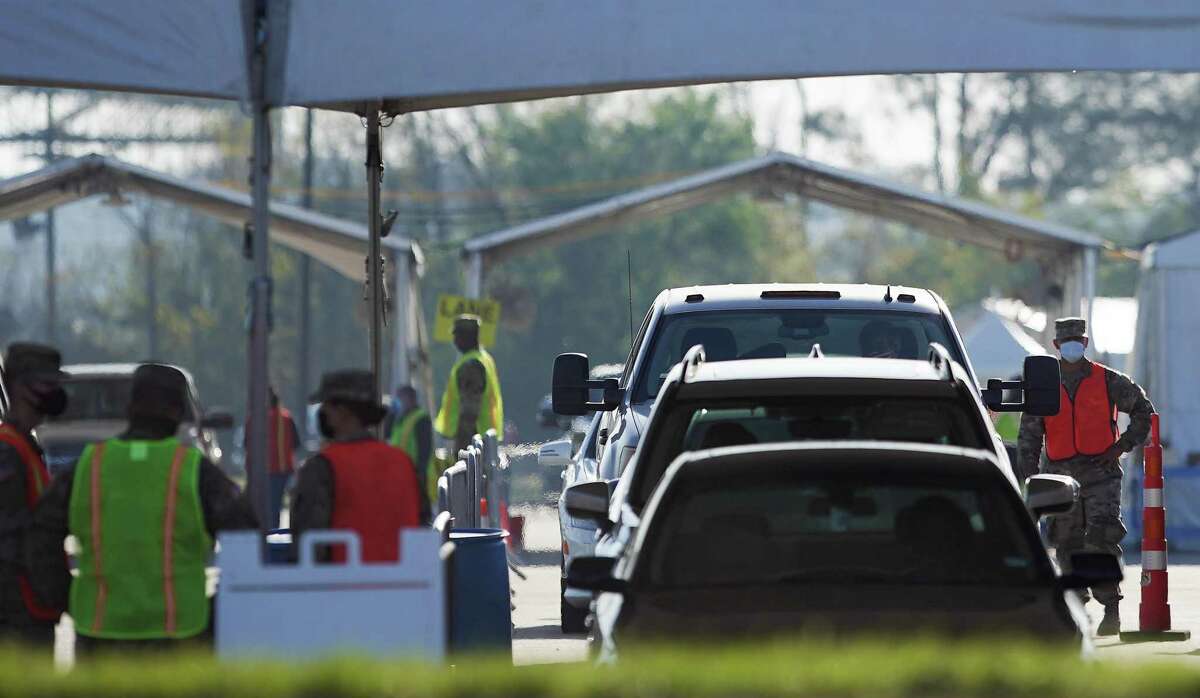 Cars line up for a waiting period after people go their vaccinations at Woodforest Bank Stadium in The Woodlands on Friday, March 26, 2021. Patients need a valid appointment with the provider to be admitted to the site. Eligibility will change on the March 29, to allow anyone over 18 to receive a shot with an appointment.