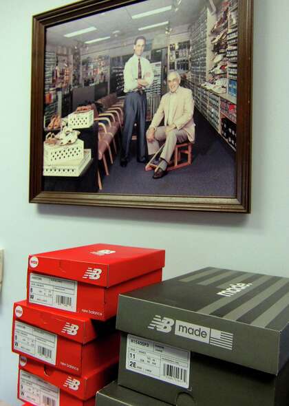 A portrait of Matt Arciuolo Sr. seated, and Matt Arciuolo Jr. hangs on the wall at Arciuolo's Shoes in Milford, Conn., on Friday March 26, 2021. The business will be celebrating its 100th anniversary in August.