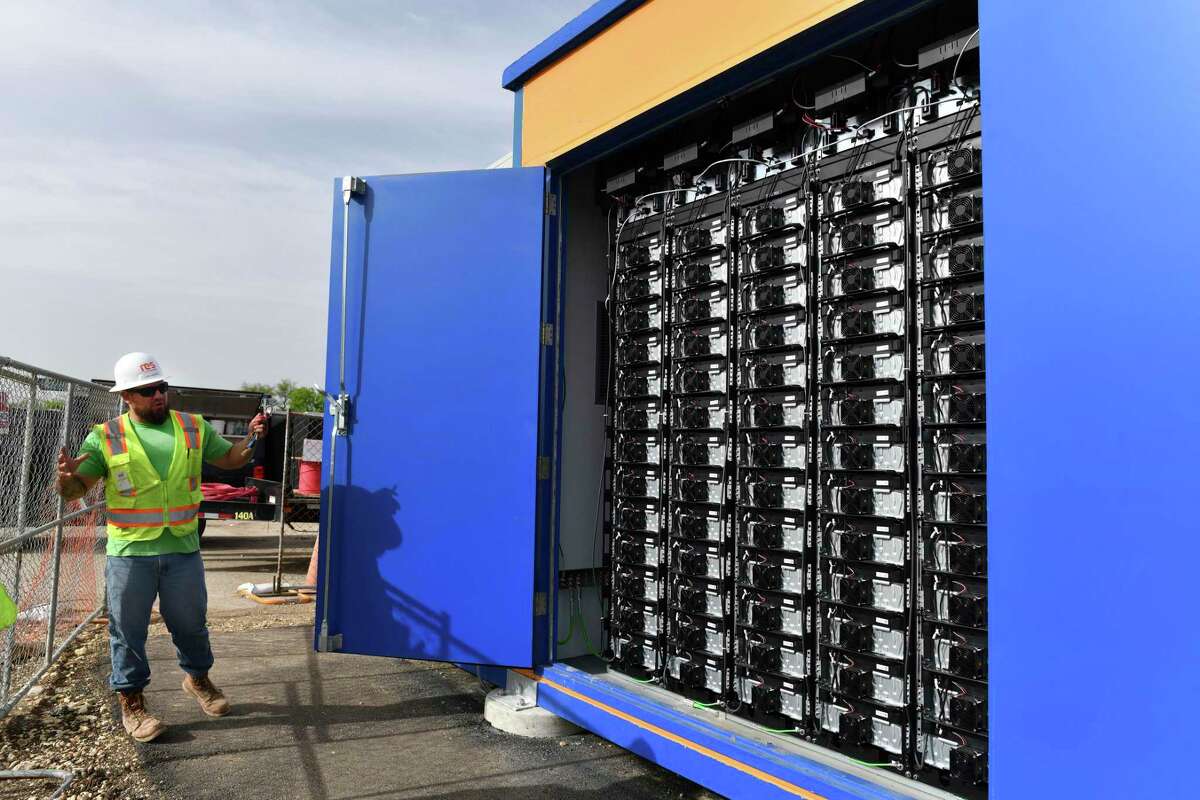 Eric Rivera opens a door to display some of the 403 batteries in one unit that holds solar-generated energy at the CPS Energy solar farm at 9800 West Commerce on Thursday, April 11, 2019.