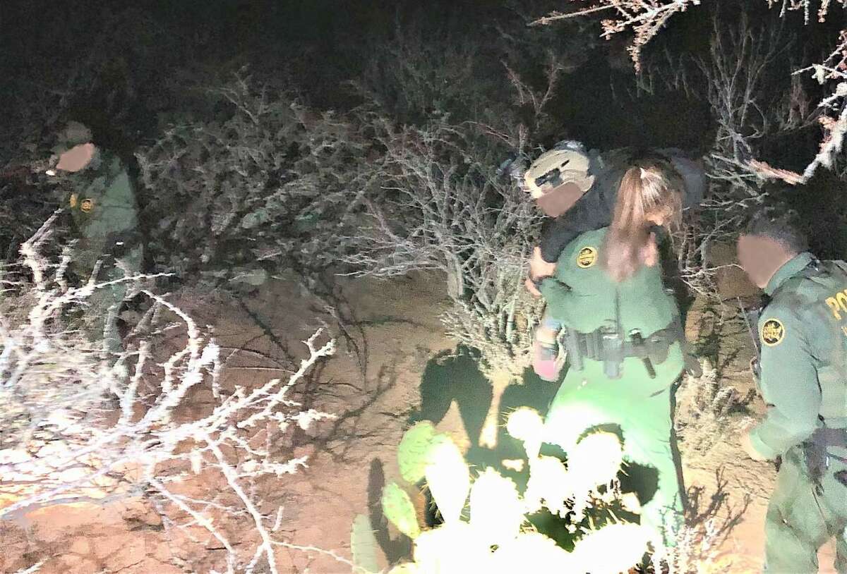 A U.S. Border Patrol agent is seen carrying a woman through the brush. The woman was an immigrant illegally present in the country who was suffering from seizures.