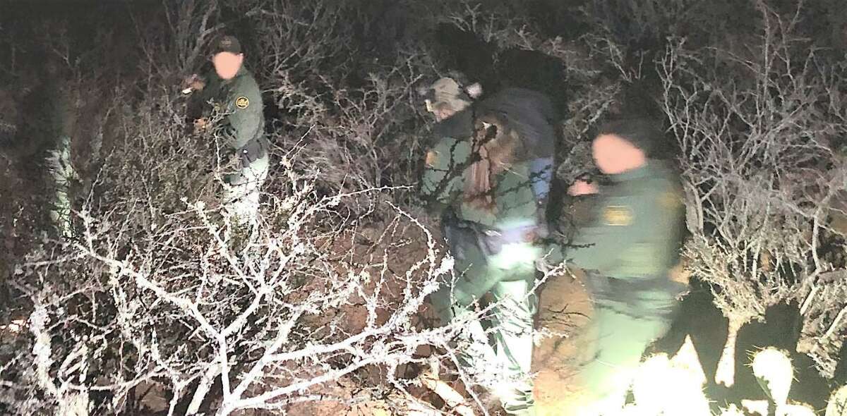 A U.S. Border Patrol agent is seen carrying a woman through the brush. The woman was an immigrant illegally present in the country who was suffering from seizures.