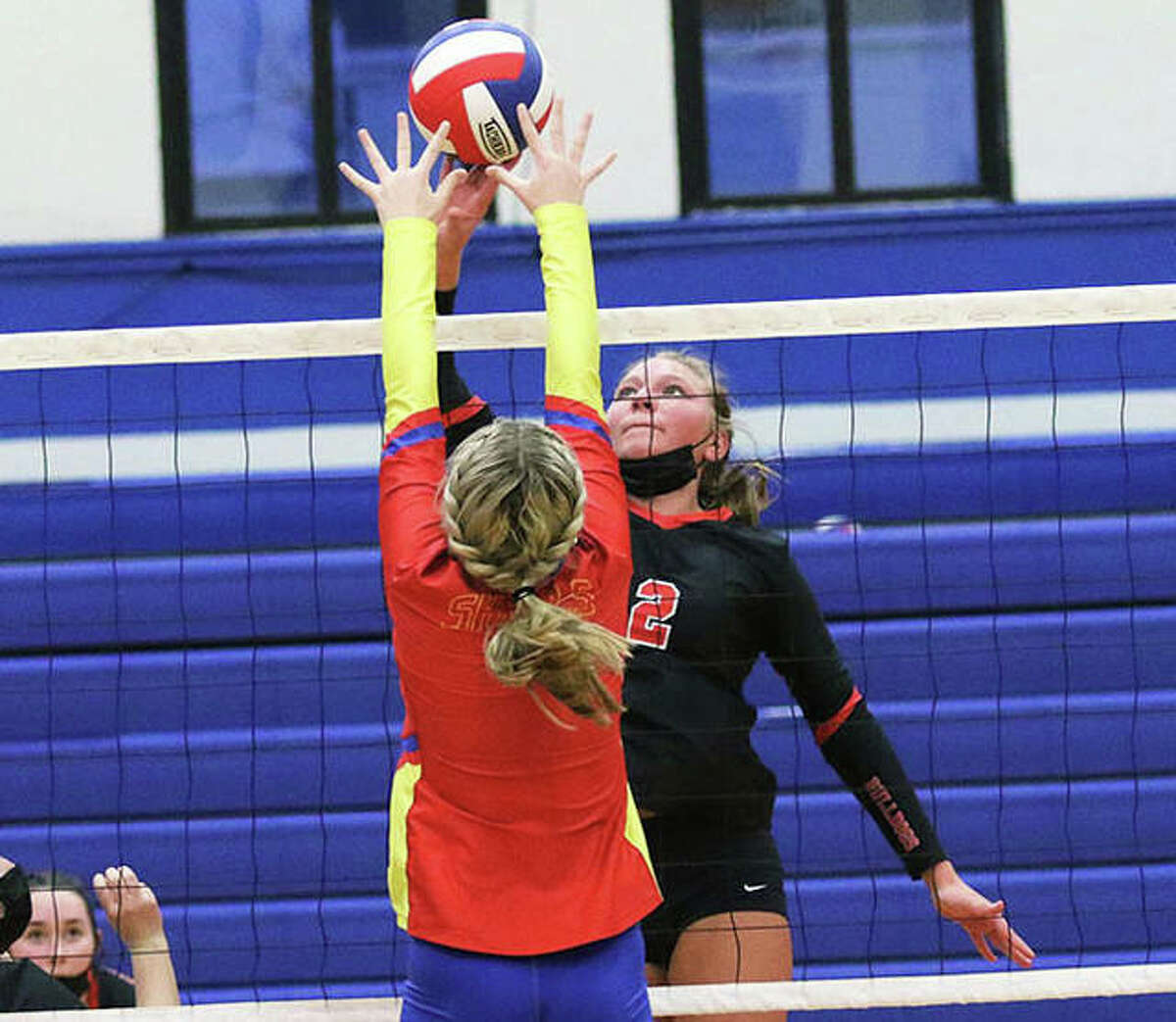 Staunton senior Taryn Russell (2) tips over the block of Roxana’s Peyton Petit during a SCC girls volleyball match March 22 at Milazzo Gym in Roxana. Russell had a career-high 14 kills in the Bulldogs’ win.