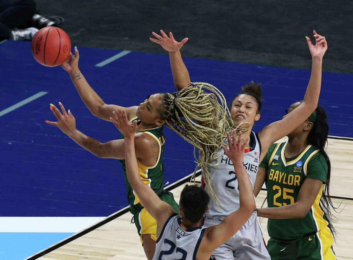 Baylor's DiJonai Carrington (21) gets fouled while going for a score while defended by University of Connecticut's Evina Westbrook (22) and Olivia Nelson-Ododa (20) during their regional championship game of the 2021 NCAA Women's Basketball tournament at the Alamodome on Monday, Mar. 29, 2021.