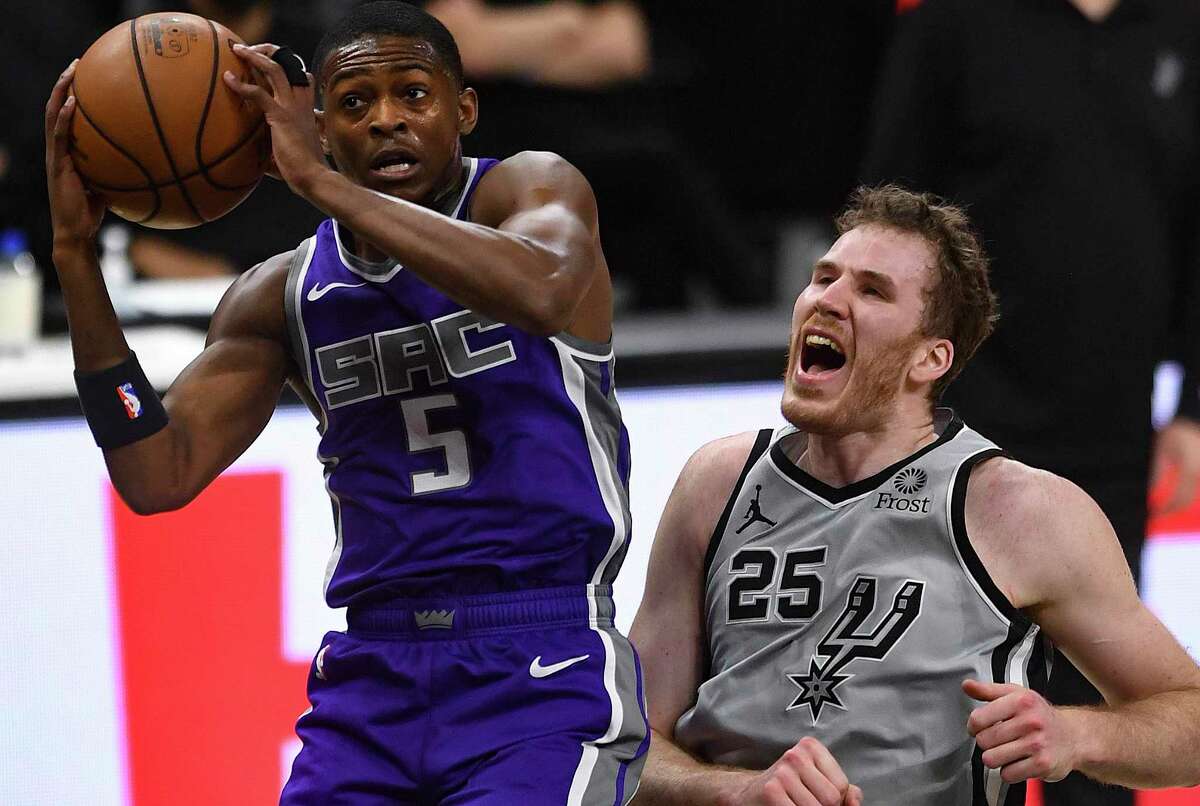 Jakob Poeltl (25) of the San Antonio Spurs screams as De'Aaron Fox of the Sacramento Kings grabs a rebound during NBA action in the AT&T Center on Monday, March 29, 2021.