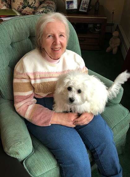 Carolyn Collins, who has late stage Alzheimer's, with Shea, her new Bichon Frise puppy, in her home in Hamden.