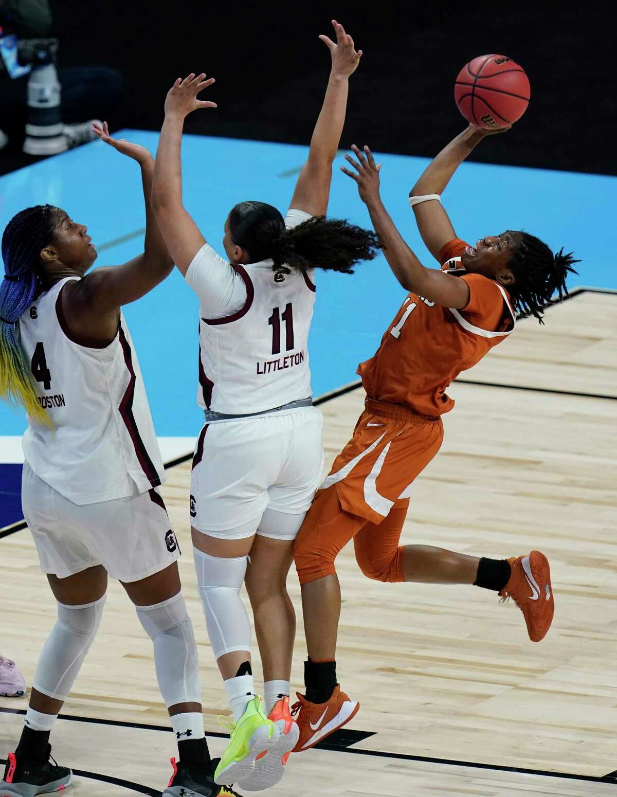 Texas guard Joanne Allen-Taylor, right, drives to the basket against South Carolina guard Destiny Littleton, center, and forward Aliyah Boston (4) during the first half of a college basketball game in the Elite Eight round of the women's NCAA tournament at the Alamodome in San Antonio, Tuesday, March 30, 2021. (AP Photo/Eric Gay)