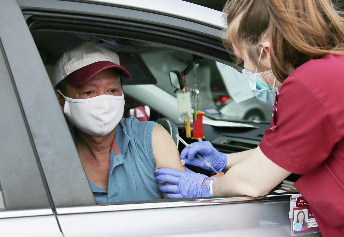 Minh Phu Tran gets a COVID-19 vaccine during a drive-thru vaccination site hosted by the Vietnamese Culture and Science Association and the Vietnamese American Medical Association in Houston on Saturday, March 13, 2021.